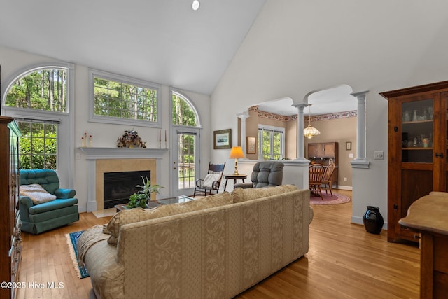6304 Wolfhead Ct, Wilmington, NC 28411 - living area featuring high vaulted ceiling, light wood finished floors, decorative columns, and a fireplace with flush hearth
