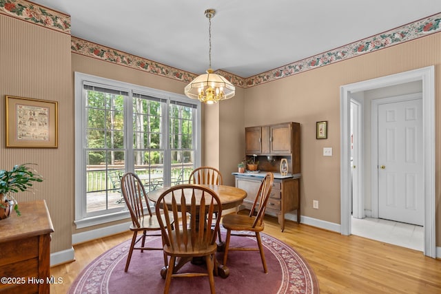 6304 Wolfhead Ct, Wilmington, NC 28411 - dining room with a chandelier, baseboards, and light wood-style flooring