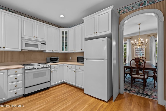 6304 Wolfhead Ct, Wilmington, NC 28411 - kitchen with white appliances, a chandelier, light wood-style floors, white cabinetry, and crown molding