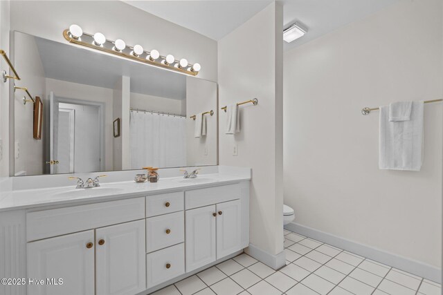 6304 Wolfhead Ct, Wilmington, NC 28411 - bathroom featuring double vanity, toilet, tile patterned flooring, and baseboards