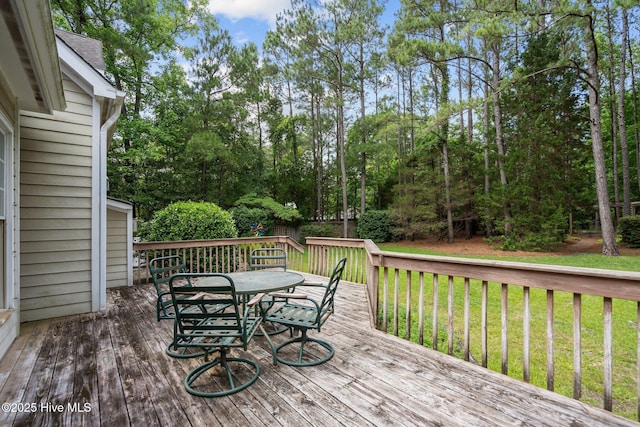 6304 Wolfhead Ct, Wilmington, NC 28411 - wooden deck with outdoor dining area, a lawn, and view of wooded area