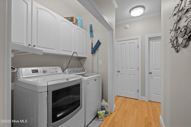 211 Tidewater Dr, Newport, NC 28570 - laundry room with cabinet space, washing machine and dryer, light wood-type flooring, and ornamental molding