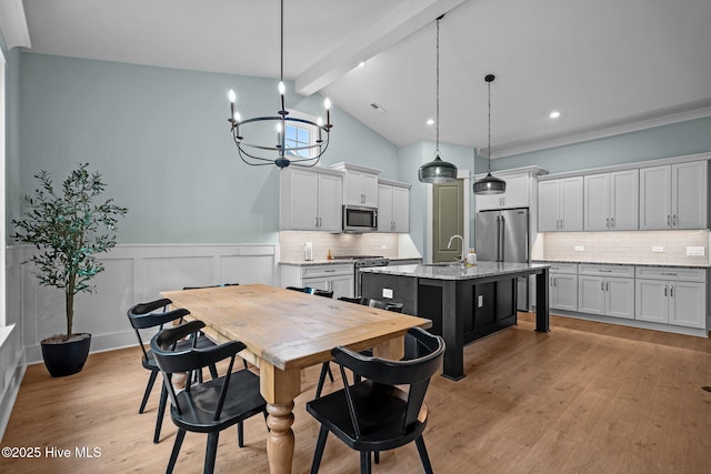 633 Ashbury Dr SE, Bolivia, NC 28422 - dining space with a chandelier, light wood-style floors, and a wainscoted wall