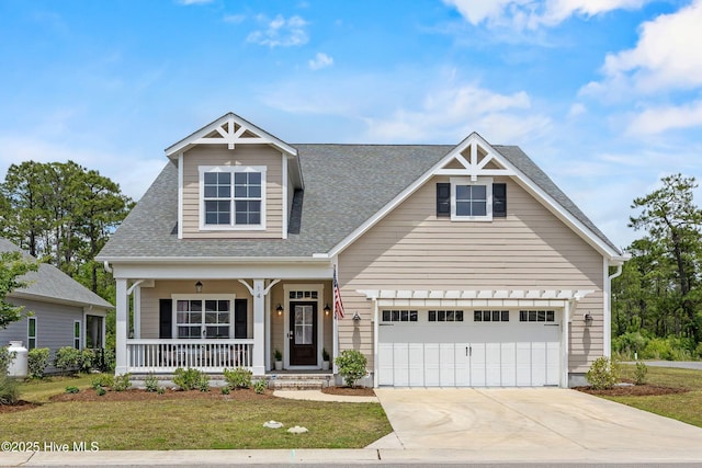 14 Allbrook Way, Hampstead, NC 28443 - view of front of home with a porch, a shingled roof, concrete driveway, a front yard, and a garage
