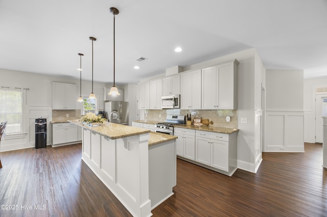 14 Allbrook Way, Hampstead, NC 28443 - kitchen featuring stainless steel appliances, dark wood-style floors, backsplash, a center island with sink, and a decorative wall