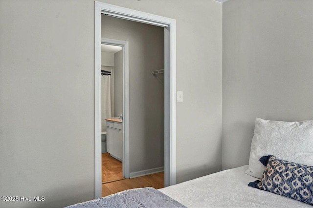 816 Colony Pl Unit D, Sunset Beach, NC 28468 - bedroom with wood finished floors, a closet, connected bathroom, and baseboards