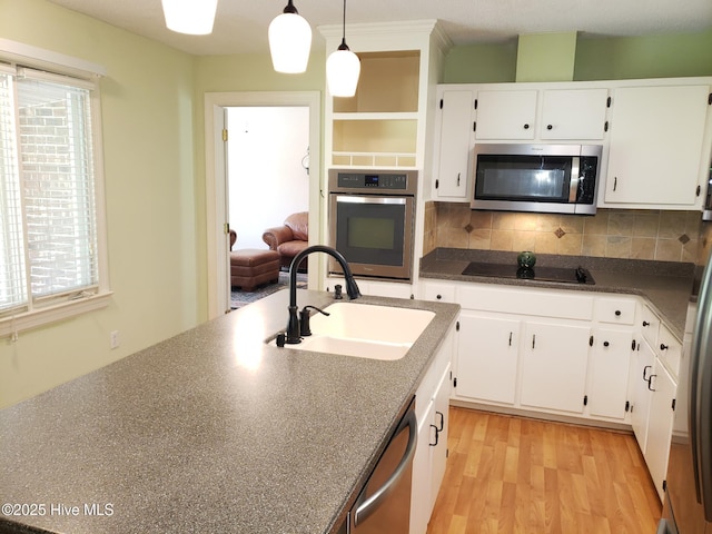 3902 Little John Dr N, Wilson, NC 27896 - kitchen with appliances with stainless steel finishes, a sink, white cabinetry, dark countertops, and backsplash