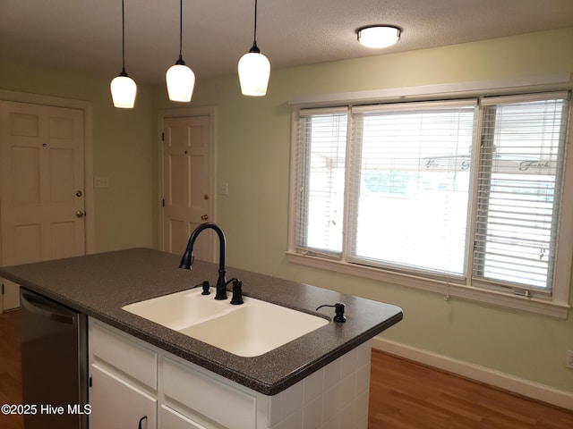 3902 Little John Dr N, Wilson, NC 27896 - kitchen featuring dark countertops, a sink, stainless steel dishwasher, and light wood-style floors
