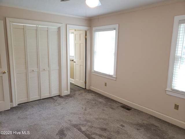 3902 Little John Dr N, Wilson, NC 27896 - unfurnished bedroom with carpet, multiple windows, ornamental molding, a closet, and baseboards