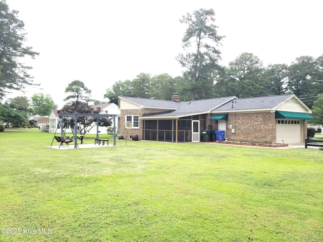 3902 Little John Dr N, Wilson, NC 27896 - back of house featuring a sunroom, brick siding, a yard, and an attached garage
