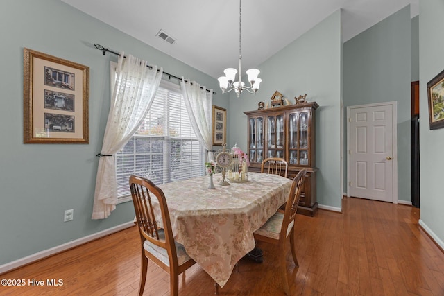 120 Leyland Way, Hampstead, NC 28443 - dining room with a chandelier, baseboards, hardwood / wood-style floors, and high vaulted ceiling