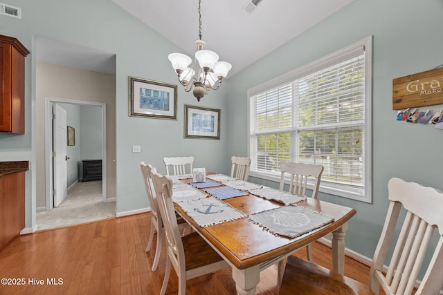 120 Leyland Way, Hampstead, NC 28443 - dining area featuring light wood-type flooring, a chandelier, vaulted ceiling, and baseboards