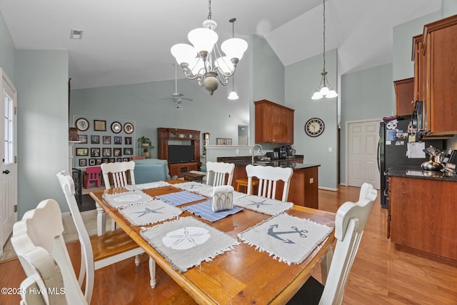 120 Leyland Way, Hampstead, NC 28443 - dining space with a chandelier, high vaulted ceiling, light wood finished floors, and ceiling fan