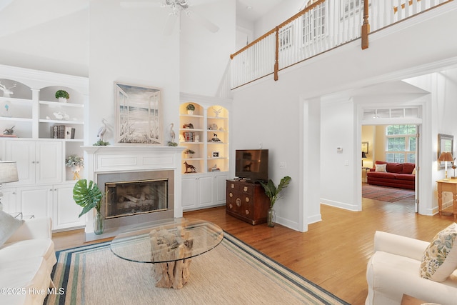 1012 Creekside Ln, Wilmington, NC 28411 - living area featuring a high ceiling, baseboards, built in features, light wood-style flooring, and a tiled fireplace
