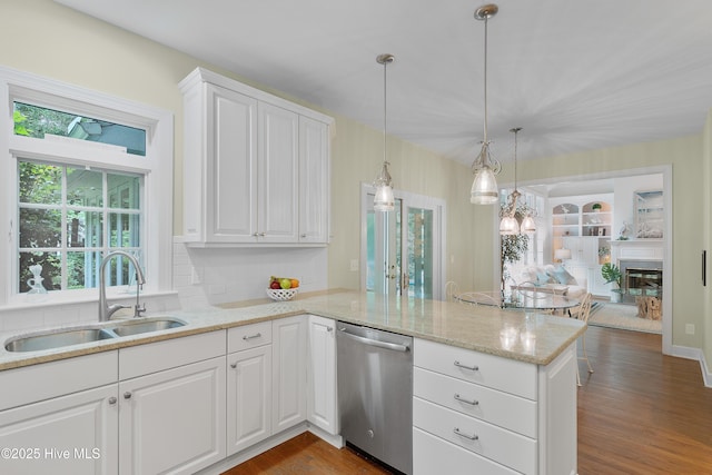 1012 Creekside Ln, Wilmington, NC 28411 - kitchen featuring stainless steel dishwasher, a sink, a peninsula, white cabinetry, and dark wood finished floors
