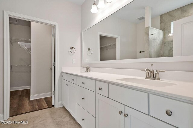 3200 Laughing Gull Ter, Wilmington, NC 28412 - full bathroom featuring double vanity, a spacious closet, and a tile shower