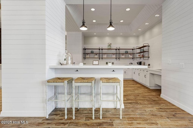 3200 Laughing Gull Ter, Wilmington, NC 28412 - kitchen with open shelves, light countertops, light wood-style flooring, white cabinets, and a kitchen bar