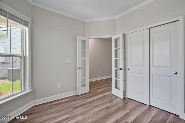 3200 Laughing Gull Ter, Wilmington, NC 28412 - unfurnished bedroom with french doors, wood finished floors, crown molding, and a closet