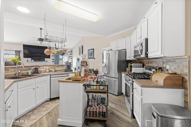 600 Pearson Cir, Newport, NC 28570 - kitchen with appliances with stainless steel finishes, a sink, tasteful backsplash, white cabinets, and vaulted ceiling