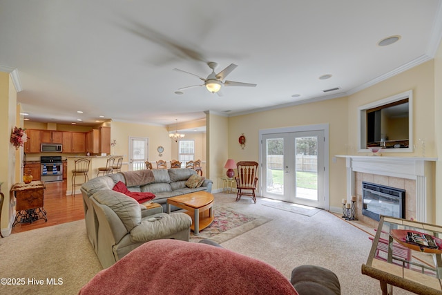 318 Winding Creek Rd, Rocky Point, NC 28457 - living area featuring crown molding, healthy amount of natural light, a chandelier, a tile fireplace, and light colored carpet