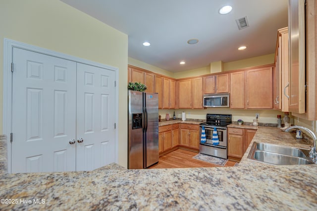 318 Winding Creek Rd, Rocky Point, NC 28457 - kitchen featuring appliances with stainless steel finishes, a sink, light wood-type flooring, recessed lighting, and light stone counters