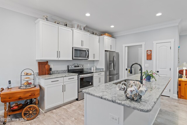 2402 W Oak Island Dr, Oak Island, NC 28465 - kitchen with stainless steel appliances, a sink, ornamental molding, light wood finished floors, and white cabinets