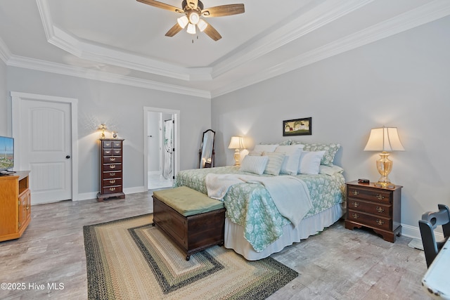 2402 W Oak Island Dr, Oak Island, NC 28465 - bedroom with a tray ceiling, light wood-style flooring, crown molding, baseboards, and ensuite bathroom