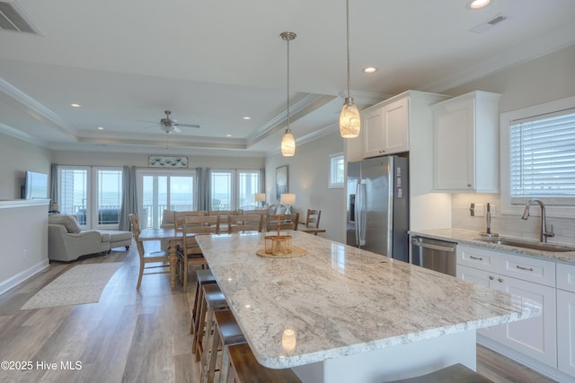 876 Villas Dr, North Topsail Beach, NC 28460 - kitchen featuring appliances with stainless steel finishes, a sink, wood finished floors, ceiling fan, and crown molding