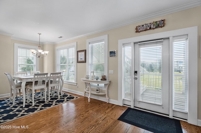 2 Clam Shell Ln Unit 6, Carolina Beach, NC 28428 - dining room with a chandelier, crown molding, wood finished floors, and baseboards