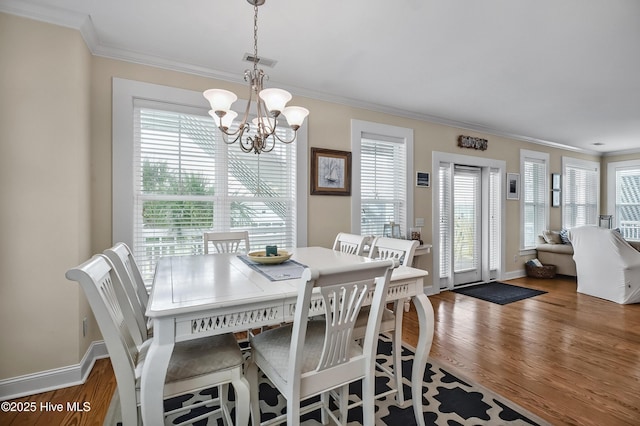 2 Clam Shell Ln Unit 6, Carolina Beach, NC 28428 - dining room with ornamental molding, a chandelier, plenty of natural light, wood finished floors, and baseboards