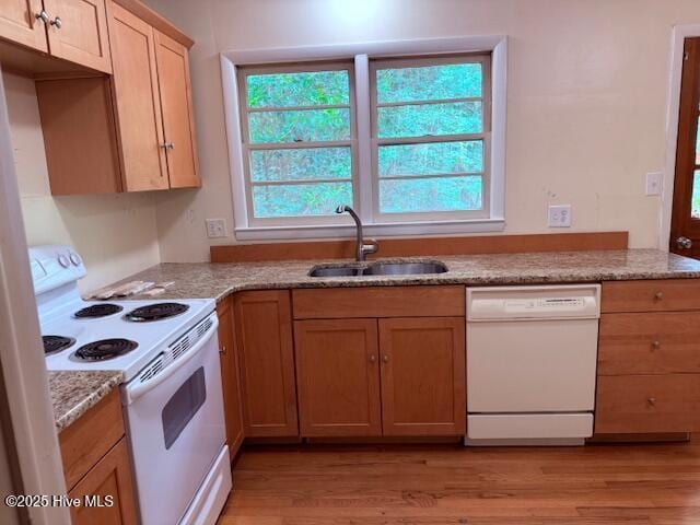 430 W Rhode Island Ave, Southern Pines, NC 28387 - kitchen featuring white appliances, a sink, light wood finished floors, and light stone countertops