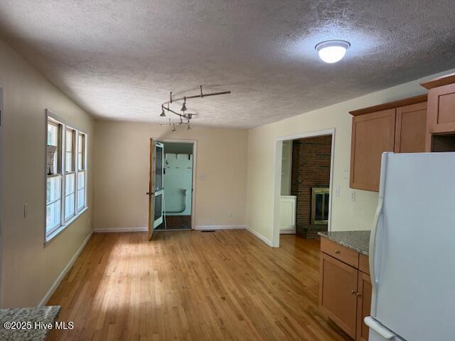430 W Rhode Island Ave, Southern Pines, NC 28387 - unfurnished dining area featuring a textured ceiling, light wood-type flooring, and baseboards
