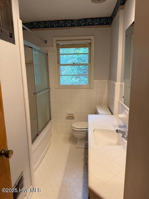 430 W Rhode Island Ave, Southern Pines, NC 28387 - bathroom with tile patterned floors, toilet, enclosed tub / shower combo, vanity, and wainscoting