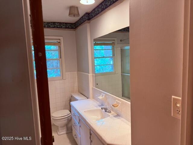 430 W Rhode Island Ave, Southern Pines, NC 28387 - full bathroom featuring plenty of natural light, toilet, vanity, an enclosed shower, and tile walls