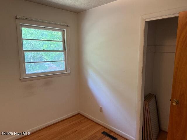 430 W Rhode Island Ave, Southern Pines, NC 28387 - unfurnished bedroom featuring baseboards, light wood-style flooring, and a textured ceiling