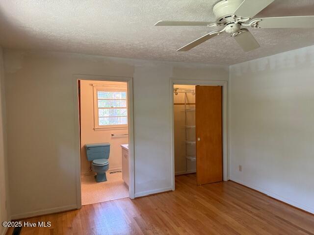 430 W Rhode Island Ave, Southern Pines, NC 28387 - unfurnished bedroom featuring light wood-style flooring, a closet, a textured ceiling, connected bathroom, and baseboards