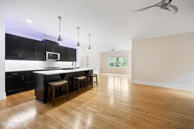 103 Schever Rd, West End, NC 27376 - kitchen featuring stainless steel microwave, ceiling fan, dark cabinetry, ornamental molding, and open floor plan
