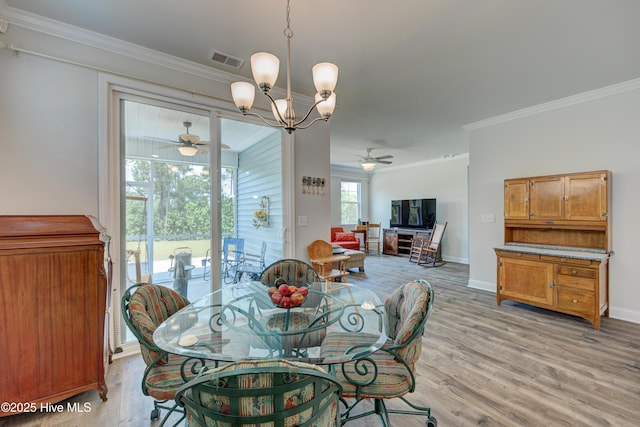 1337 Fence Post Ln, Carolina Shores, NC 28467 - dining room with ceiling fan, crown molding, light wood-style floors, a chandelier, and baseboards
