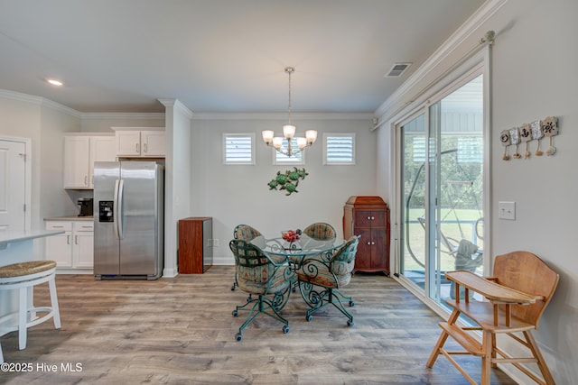 1337 Fence Post Ln, Carolina Shores, NC 28467 - dining room featuring light wood-type flooring, a chandelier, crown molding, and baseboards