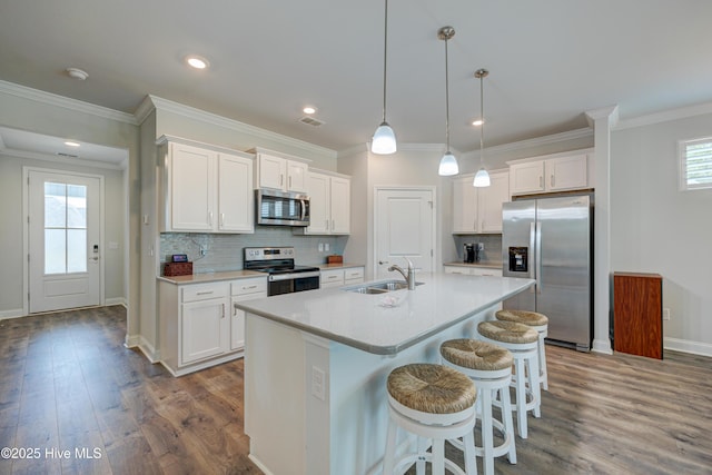 1337 Fence Post Ln, Carolina Shores, NC 28467 - kitchen with stainless steel appliances, white cabinetry, an island with sink, dark wood-type flooring, and recessed lighting