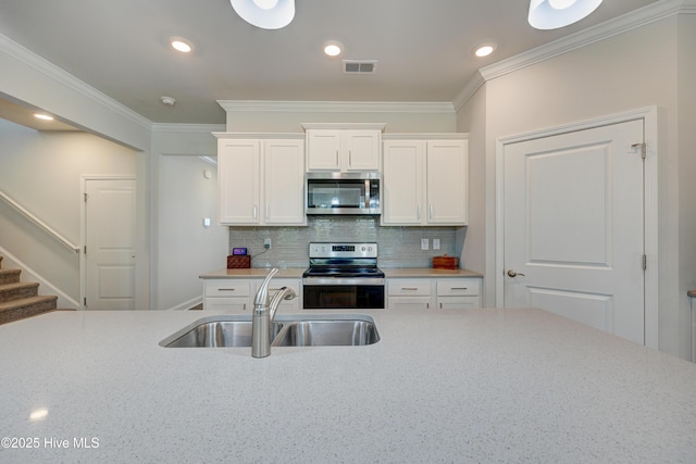 1337 Fence Post Ln, Carolina Shores, NC 28467 - kitchen with stainless steel appliances, a sink, white cabinets, crown molding, and backsplash