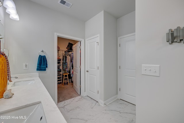 1337 Fence Post Ln, Carolina Shores, NC 28467 - bathroom featuring marble look tile flooring, double vanity, and a walk in closet