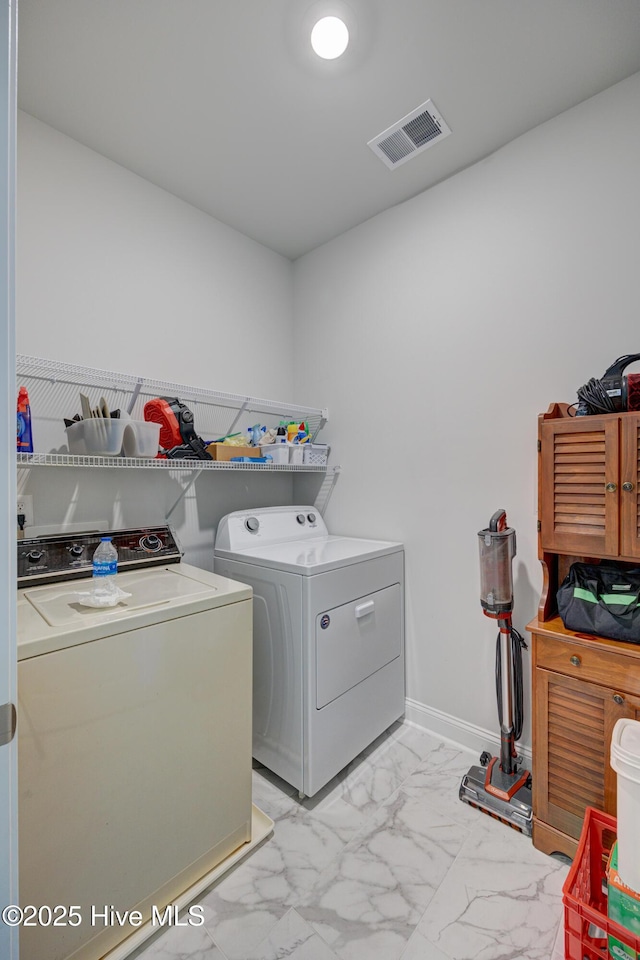 1337 Fence Post Ln, Carolina Shores, NC 28467 - laundry area featuring separate washer and dryer, light marble finish floors, and baseboards