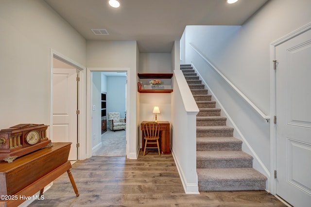1337 Fence Post Ln, Carolina Shores, NC 28467 - stairs featuring wood finished floors, recessed lighting, and baseboards