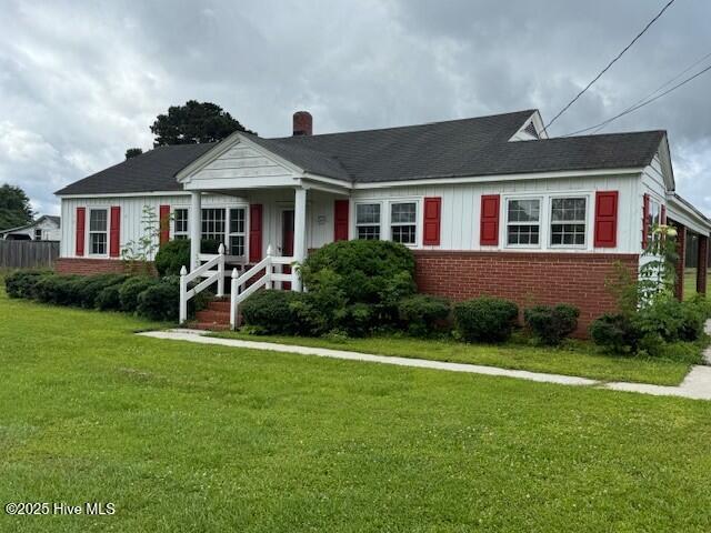 214 NC Highway 561 E, Ahoskie, NC 27910 - bungalow-style home with brick siding, a front yard, board and batten siding, and a chimney