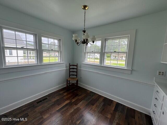 214 NC Highway 561 E, Ahoskie, NC 27910 - unfurnished dining area with a chandelier, dark wood-type flooring, and baseboards