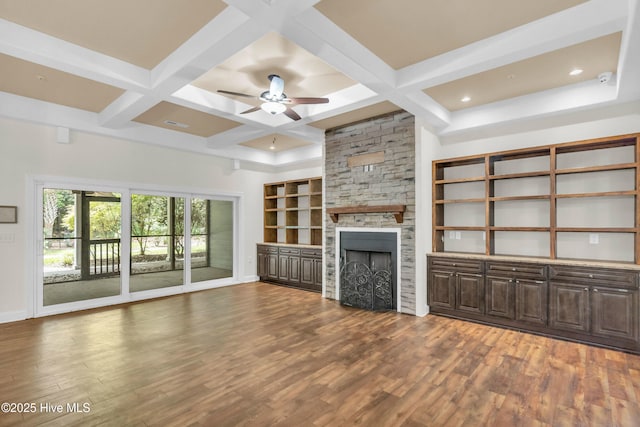 1120 Beasley Rd, Wilmington, NC 28409 - unfurnished living room featuring coffered ceiling, wood finished floors, a stone fireplace, ceiling fan, and beamed ceiling