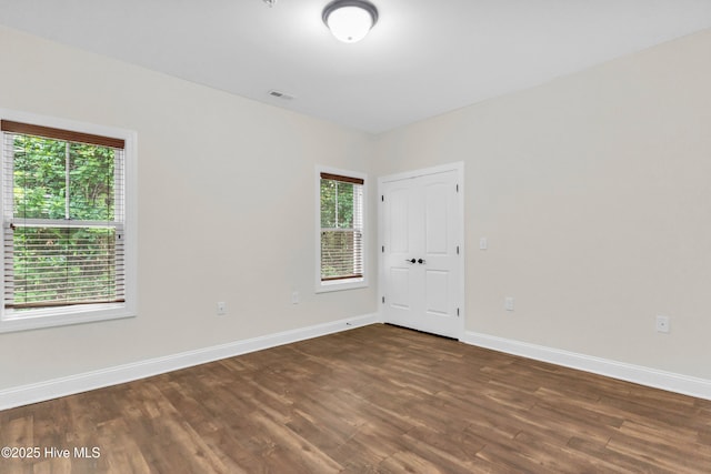 1120 Beasley Rd, Wilmington, NC 28409 - empty room with dark wood-style floors and healthy amount of natural light