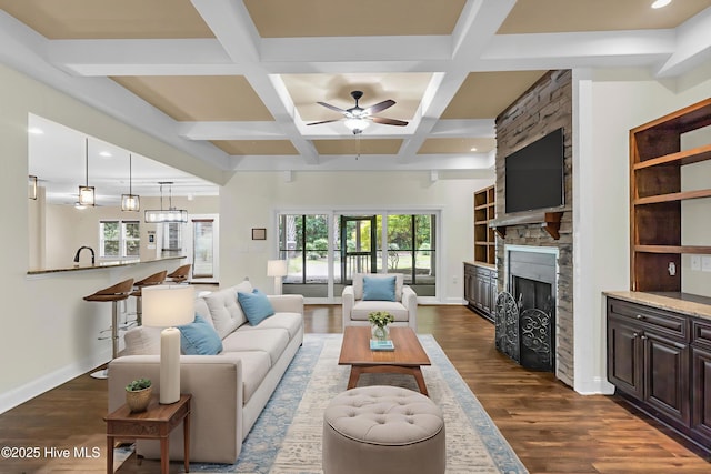 1120 Beasley Rd, Wilmington, NC 28409 - living area featuring a stone fireplace, dark wood-type flooring, ceiling fan, beam ceiling, and recessed lighting