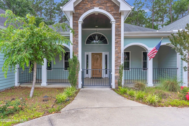 1120 Beasley Rd, Wilmington, NC 28409 - entrance to property with covered porch, stone siding, and a shingled roof